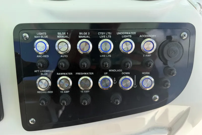 Slide: The Image of Control panel of a 2018 NauticStar 28 XS boat with various switches and buttons. - 34