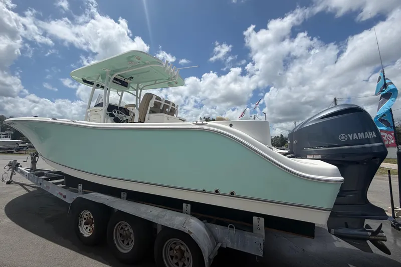 Slide: The Image of 2018 NauticStar 28 XS boat on trailer with Yamaha engine under cloudy sky. - 11
