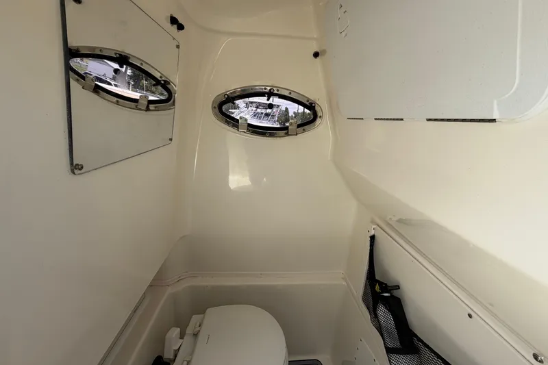 Slide: The Image of Interior of 2018 NauticStar 28 XS boat cabin with portholes and toilet. - 45