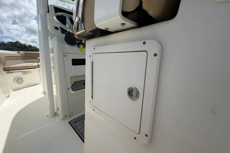 Slide: The Image of 2018 NauticStar 28 XS boat interior, featuring a storage compartment and steering wheel. - 26
