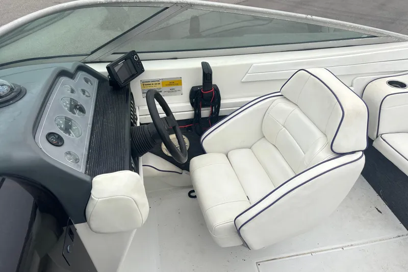 Slide: The Image of 1994 Formula 232 LS boat cockpit with white seating and dashboard controls. - 13