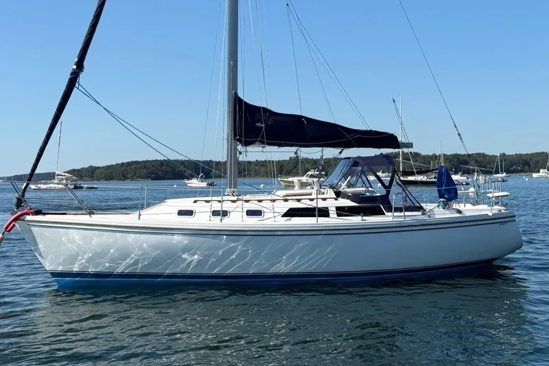 The Image of 1988 Catalina 34 sailboat anchored on calm water under clear blue sky. - 0