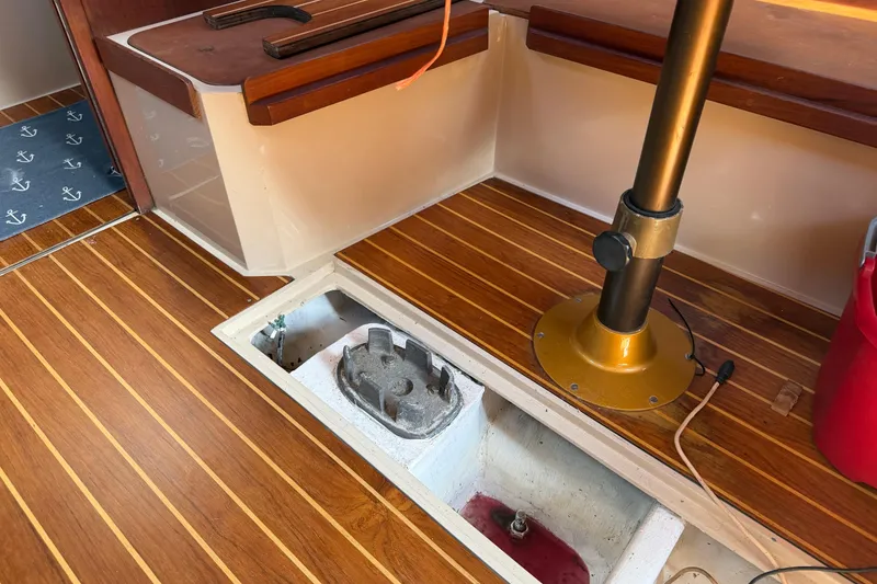 Slide: The Image of Interior of a 1988 Catalina 34 sailboat showing wooden flooring and storage compartment. - 13