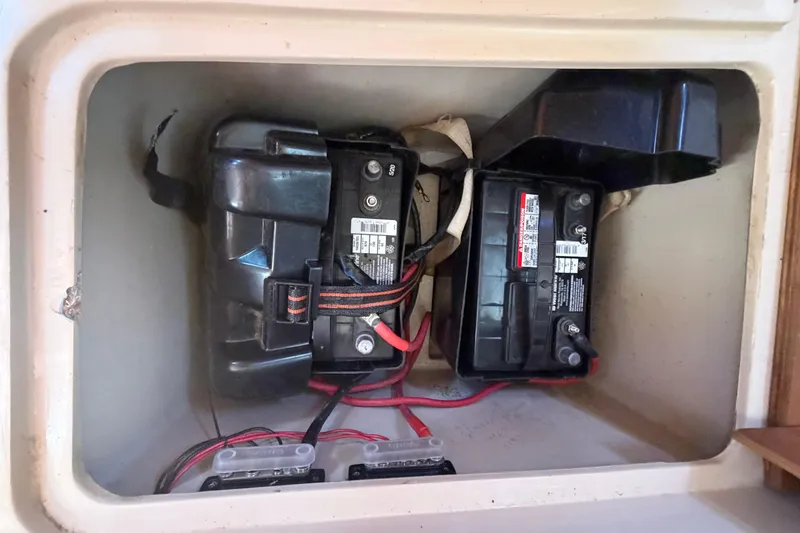 Slide: The Image of Battery compartment of a 1988 Catalina 34 sailboat, featuring two batteries and wiring. - 15