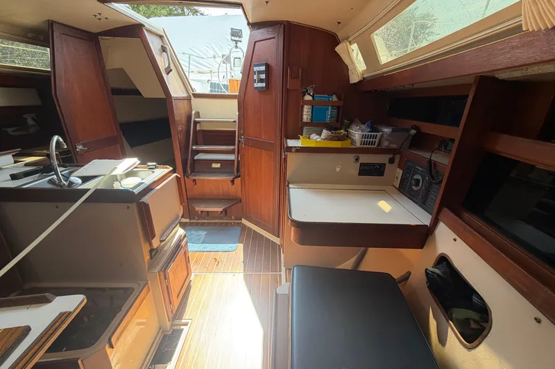 Slide: The Image of Interior of a 1988 Catalina 34 sailboat, featuring wood cabinetry and compact kitchen area. - 2