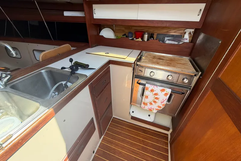 Slide: The Image of Interior of a 1988 Catalina 34 sailboat kitchen with sink and stove. - 4