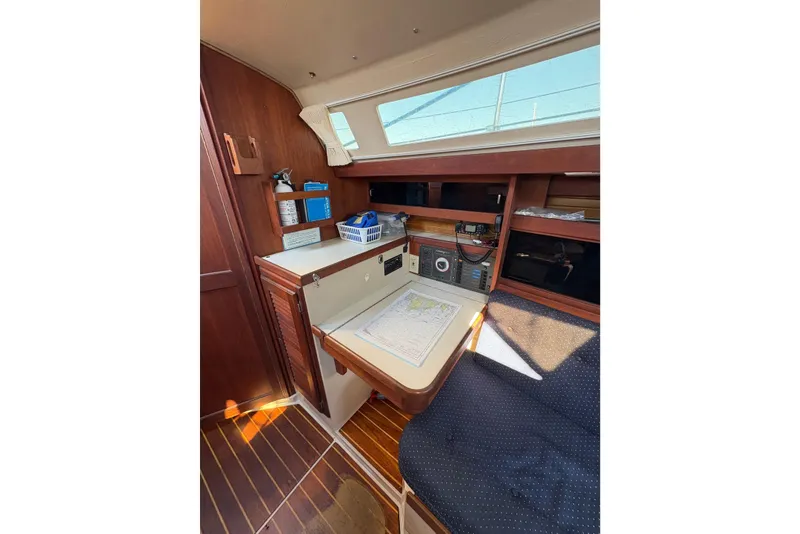 Slide: The Image of Navigation station inside a 1988 Catalina 34 sailboat, featuring a chart table and equipment. - 5