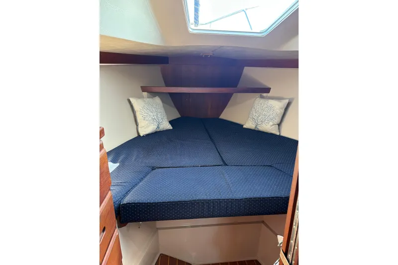 Slide: The Image of Cozy cabin interior of 1988 Catalina 34 sailboat with blue bedding and decorative pillows. - 7