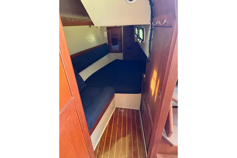 Slide: The Image of Interior cabin of 1988 Catalina 34 sailboat with wooden flooring and cushioned seating. - 8