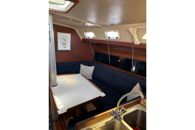 Slide: The Image of Cozy interior of 1988 Catalina 34 sailboat with dining area and sink. - 9