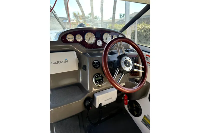 Slide: The Image of 2011 Regal 2565 Express Cruiser helm with Garmin navigation and wood steering wheel. - 5