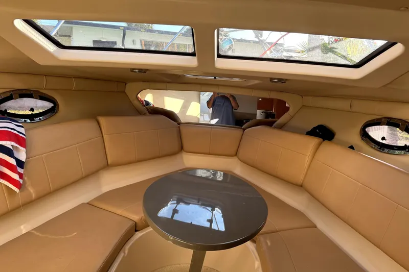 Slide: The Image of Interior of 2011 Regal 2565 Express Cruiser with beige seating and skylights. - 9
