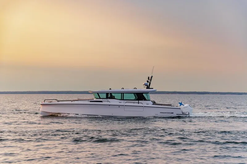 The Image of 2027 Axopar 45 XC Cross Cabin cruising on calm waters at sunset. - 0