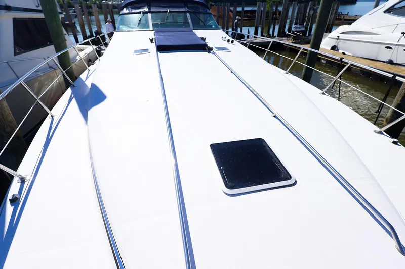 Slide: The Image of 1998 Sea Ray 500 Sundancer yacht deck, docked at marina, showcasing sleek design and spacious layout. - 10