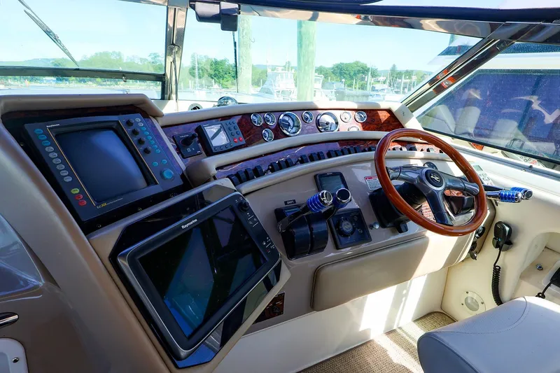 Slide: The Image of Cockpit of 1998 Sea Ray 500 Sundancer with navigation equipment and wooden steering wheel. - 23