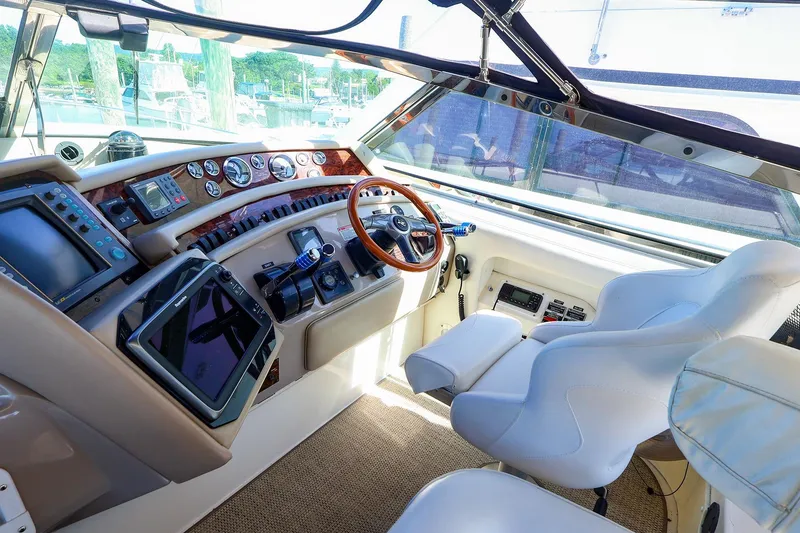 Slide: The Image of Cockpit of 1998 Sea Ray 500 Sundancer with modern navigation equipment and plush seating. - 24