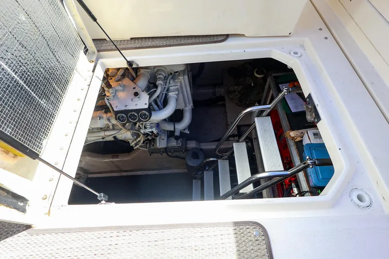 Slide: The Image of Engine compartment of a 1998 Sea Ray 500 Sundancer yacht, showing mechanical components and access ladder. - 57