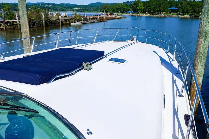 Slide: The Image of 1998 Sea Ray 500 Sundancer yacht docked by scenic waterfront. - 6