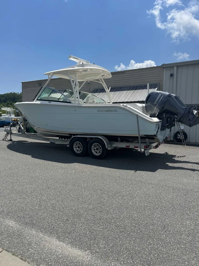 The Image of A 2021 Cobia 280 DUAL boat on a trailer, parked in a lot. - 1