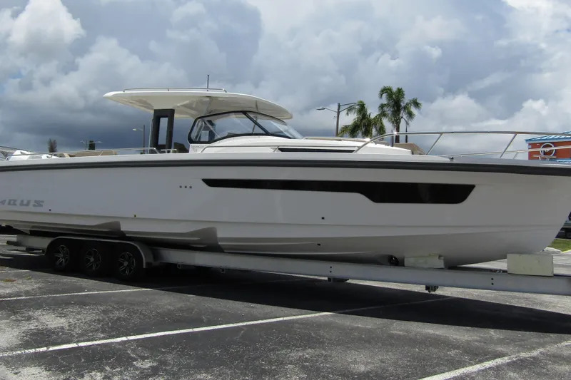 Slide: The Image of 2025 Nimbus Tender 11 boat on trailer under cloudy sky, parked in lot. - 2