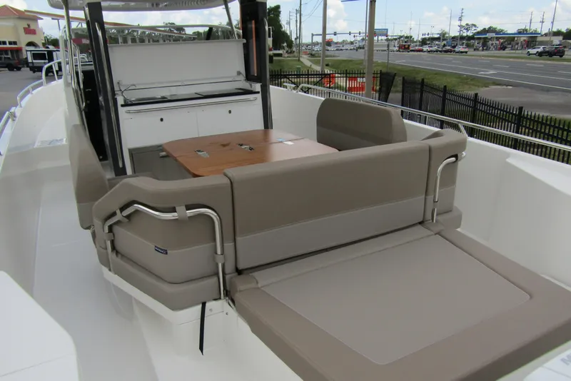 Slide: The Image of 2025 Nimbus Tender 11 boat interior with seating and table, docked near a road. - 45