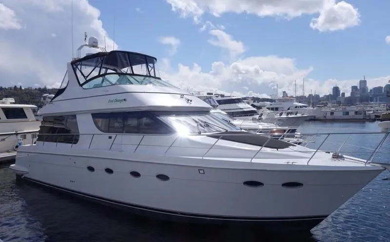 The Image of 2000 Carver 530 Voyager Pilothouse yacht docked at marina under blue sky. - 0