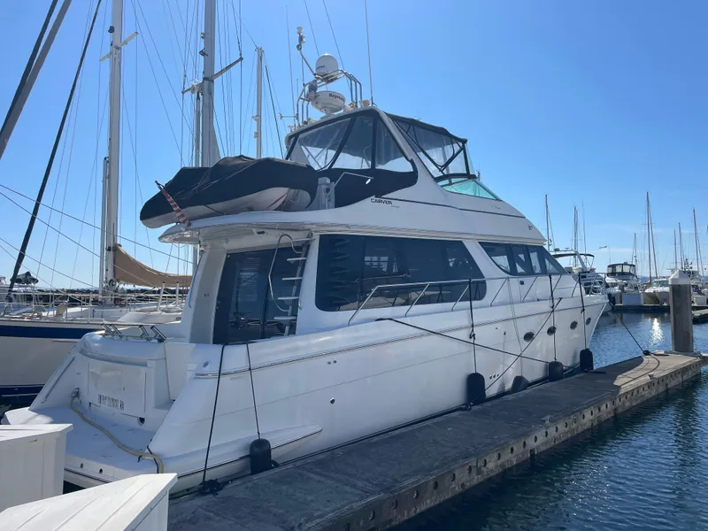 Slide: The Image of 2000 Carver 530 Voyager Pilothouse yacht docked at marina under clear blue sky. - 1