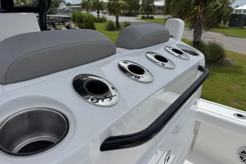 Slide: The Image of 2027 Caymas 26 HB boat with rod holders and cup holders on deck. - 17