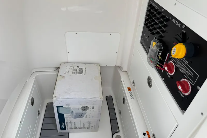 Slide: The Image of Interior of 2027 Caymas 26 HB boat showing electrical panel and packaged item. - 23