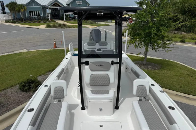 Slide: The Image of 2027 Caymas 26 HB boat with sleek interior design, parked near a marina. - 26