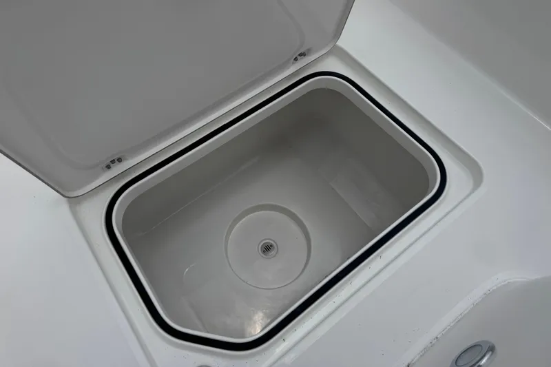 Slide: The Image of Open storage compartment on 2027 Caymas 26 HB boat, featuring a sleek white interior. - 28