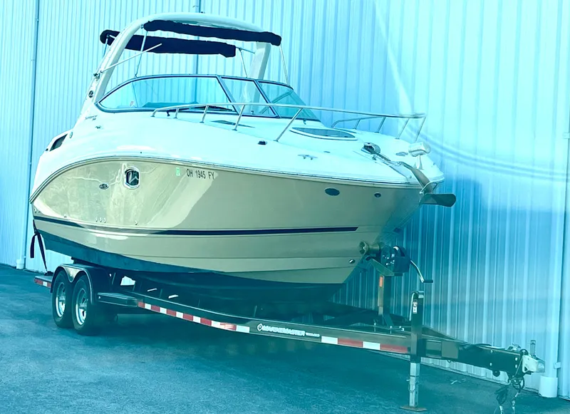 Slide: The Image of A Sea Ray Sundancer 260 boat on a trailer in front of a building. - 2