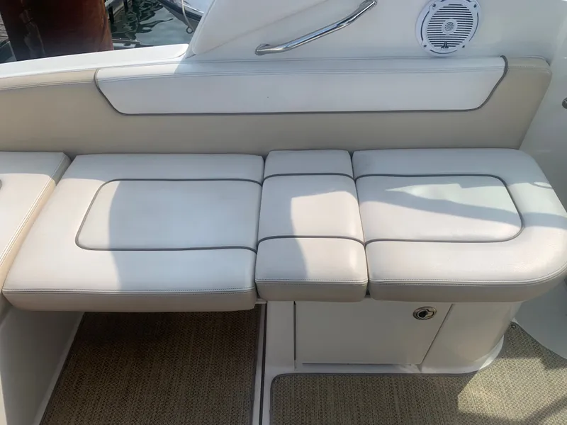 Slide: The Image of White cushioned bench on a boat with speaker and handrail. - 5