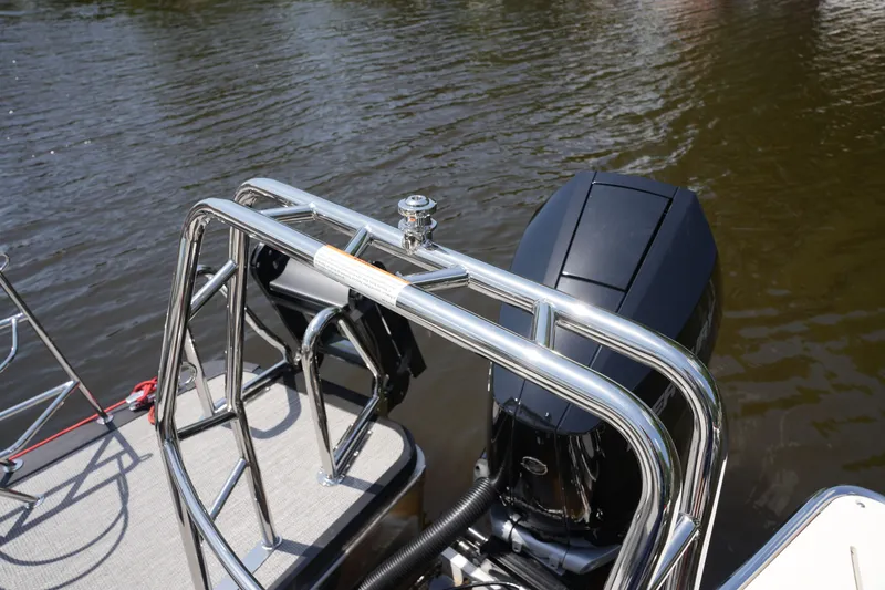 Slide: The Image of A 2027 Harris 250GM with shiny railing and outboard motor on calm water. - 36