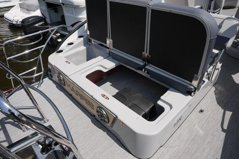 Slide: The Image of The image shows the stern of a 2027 Harris 250GM boat with storage and speakers. - 34