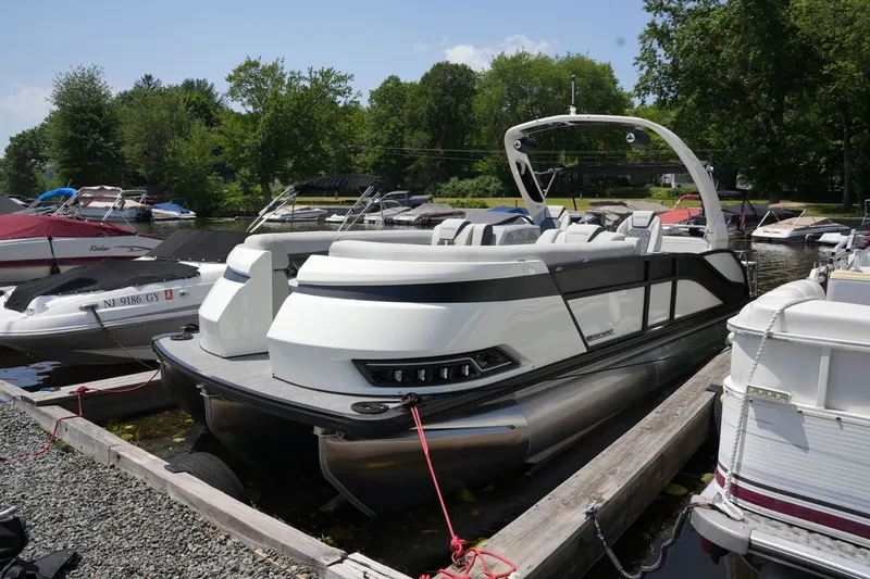Slide: The Image of A modern pontoon boat with sleek white and gray accents, docked in a tranquil marina. - 10