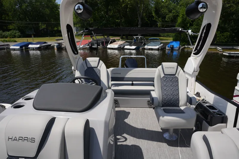 Slide: The Image of The image shows a modern Harris pontoon boat, model 250GM, year 2027, on the water. - 19