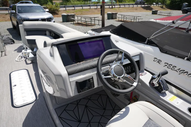 Slide: The Image of The image shows the cockpit of a 2027 Harris 250GM boat with a modern helm. - 23