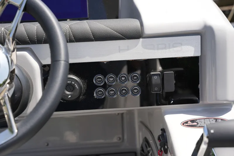 Slide: The Image of Close-up of a 2027 Harris 250GM helm with multiple buttons and a steering wheel. - 27