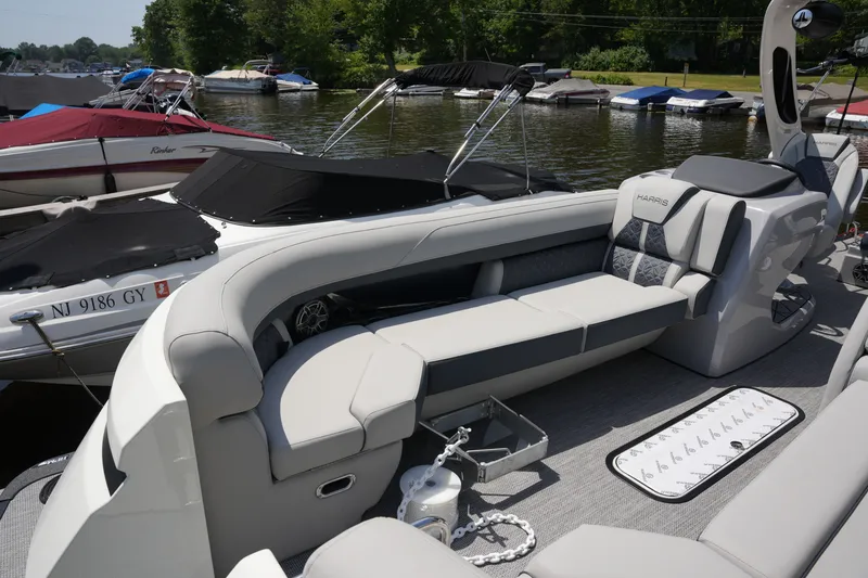 Slide: The Image of A luxurious pontoon boat with sleek seating and modern features, docked by a calm lakeside. - 13
