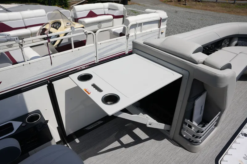Slide: The Image of Interior of a Harris 250GM pontoon boat with a fold-out table and cup holders. - 18