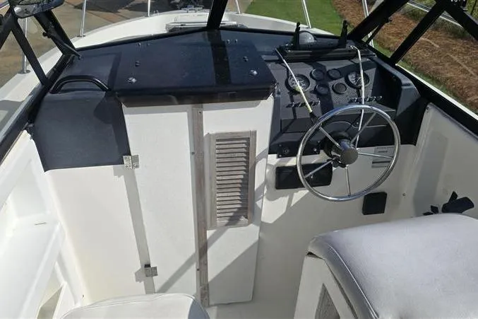 Slide: The Image of 1996 Bayliner Trophy Walkaround cockpit with steering wheel and control panel. - 5