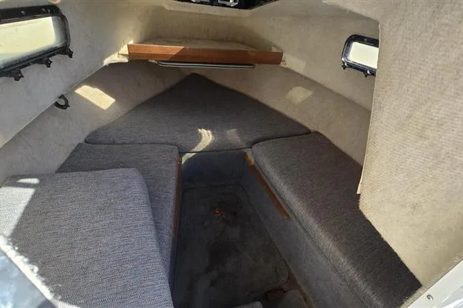 Slide: The Image of Interior cabin of 1996 Bayliner Trophy Walkaround boat with cushioned seating and small windows. - 6
