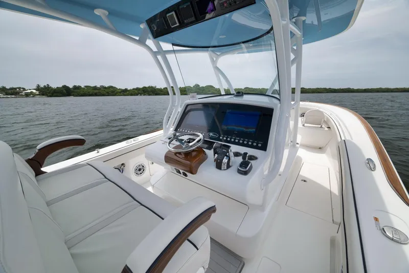 Slide: The Image of 2023 Valhalla Boatworks V-33 helm with modern controls and luxurious seating on open water. - 33