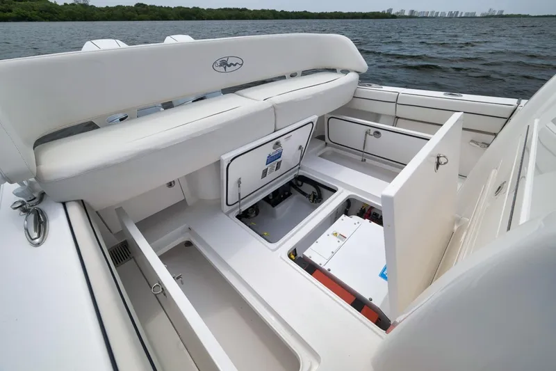 Slide: The Image of 2023 Valhalla Boatworks V-33 interior with open storage compartments on a calm water backdrop. - 40