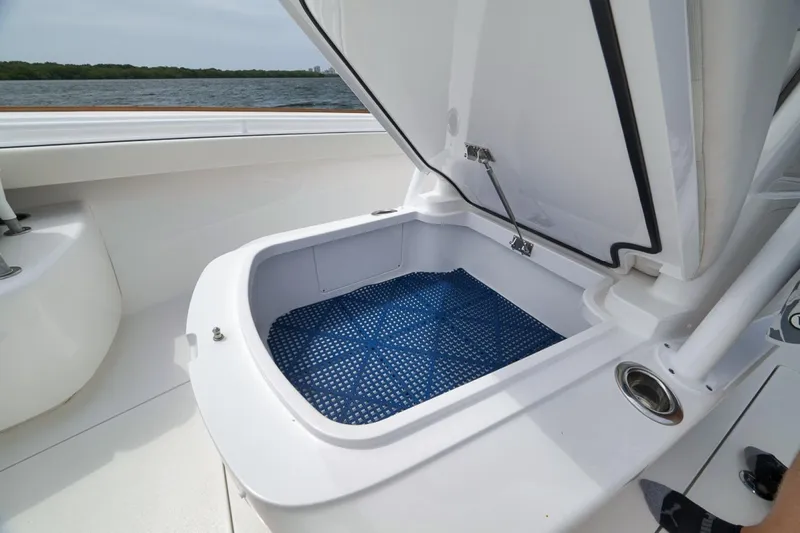 Slide: The Image of Open storage compartment on 2023 Valhalla Boatworks V-33, featuring blue mat lining. - 26