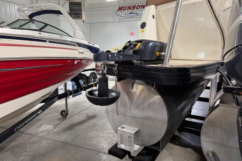 Slide: The Image of 2018 Godfrey Sanpan 2500 ULC pontoon boat in showroom, alongside a red Chaparral boat. - 20