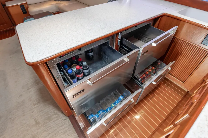 Slide: The Image of Luxury yacht galley with open stainless steel drawers, stocked with beverages, on a Custom Carolina Scarborough 56 Convertible. - 21