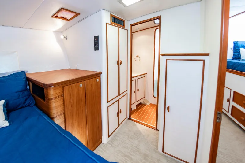 Slide: The Image of Interior of 1993 Custom Carolina Scarborough 56 Convertible yacht with wood accents and blue bedding. - 28