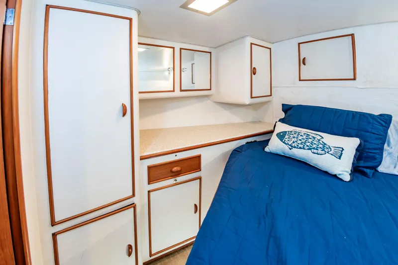 Slide: The Image of Cozy cabin interior of 1993 Custom Carolina Scarborough 56 Convertible with blue bedding and fish pillow. - 39